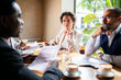 © Marko Geber - Business meeting in a cafe with diverse professionals
