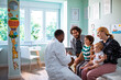 © Marko Geber - Family at pediatrician's office for children's check-up with doctor