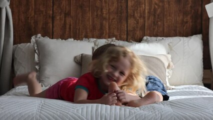 Poster - Cute sweet toddler children, tickling feet on the bed, laughing and smiling