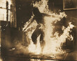 © Domingo - Silhouette of a person engulfed in flames, burned, surrounded by fire, inside a house with burning windows. Old photograph of a paranormal phenomenon of spontaneous combustion.