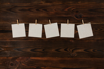 Sticker - paper cards hanging on the rope on wooden background
