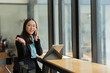 © Thitisak - Asian woman talking on smartphone with customer Business matters