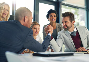 Serious, businessmen and arm wrestle in office for rival challenge and workplace disagreement. Male employees, team building and meeting in boardroom for corporate competition, conflict or contest