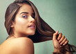 © Arnell Koegelenberg/peopleimages.com - Woman, studio or hand pulling for hair care, treatment for healthy strength. Female person, beauty transformation or green background in portrait for wellness, cosmetics or aesthetic in New York