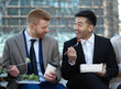 © PapatoniC - Front view of two business colleagues men eating outdoors healthy home made salads