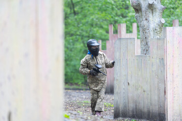 Warriors in camouflage and masks playing paintball