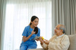© Suney - Female health care worker is take care senior man at home.