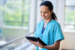 © Meeko Media - Smiling Nurse in Hospital Scrubs Using Digital Tablet in Modern Medical Facility