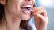 © NK - Woman inserting clear aligner for teeth straightening