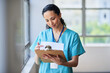 © Meeko Media - Focused Nurse Reviewing Patient Records On Clipboard In Hospital