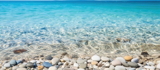 Poster - Close-up of smooth beach pebbles under clear water on the sand, creating a natural and tranquil vacation-themed copy space image.