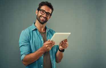 Poster - Man, studio and portrait with tablet and glasses, career with software programming in London. Male creative, space or gray background with happiness for digital job, mobile app or website development