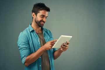 Poster - Tablet, smile and studio with man online, communication and social media on gray background. Internet, online and scroll for texting on dating app, talk or happy male person on mobile for love