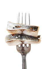 Wall Mural - Pieces of salted herring on fork isolated on white background