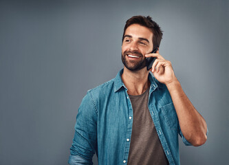 Poster - Happy man, fashion and phone call in studio with style, cheerful on mobile in gray background. Male person, smile and outfit for confidence, retail or sale in communication for promo in denim shirt