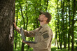 © New Africa - Forester with laptop examining tree in forest