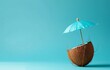© Jaume Pera - A summertime scene featuring a coconut drink with a blue umbrella against a blue background. The minimalist presentation emphasizes the refreshing and tropical essence of summer.