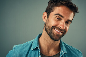 Poster - Studio backdrop, man and fashion for style in portrait, trendy or cheerful with smile. Male person, happy and outfit with confidence, retail or sale in advertisement or promotion in gray background