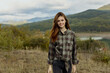 © SHOTPRIME STUDIO - A woman in casual plaid shirt and jeans enjoying serene mountain lake view in nature travel scene