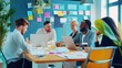 © OMD - A vibrant office setting with a diverse group of colleagues engaging in a lively discussion, surrounded by laptops, documents, and colorful sticky notes.