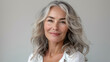 © SITI - Elegant mature woman with silver hair smiling, representing natural beauty and graceful aging
