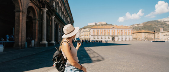 Wall Mural - Young attractive smiling girl tourist exploring new city at summer