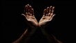 © Emin - Praying hands against dark background in stock image