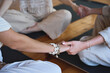 © insta_photos - Yoga coach holding hands of women group during holistic healing session. Mindful ladies sitting in circle meditating together doing breathing exercises giving support at body care training. Close up.