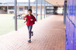 © WavebreakMediaMicro - In school, young biracial male student is running by lockers outdoors