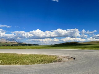 Wall Mural - Empty road with curve under a clear sky