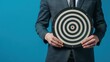 © Dekastro - businessman holding a dartboard on a neutral background