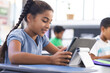 © Wavebreak Media - In school, young biracial female student using a tablet in the classroom