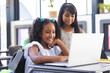 © Wavebreak Media - In school, two young biracial female students looking at a laptop screen in the classroom