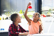 © Wavebreak Media - In school, biracial girl and boy are looking at red liquid in flask, doing a science experiment