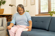 © Wavebreak Media - At home, biracial senior woman checking blood pressure on couch in living room, copy space
