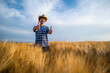 © djoronimo - Happy farmer standing in his wheat field.