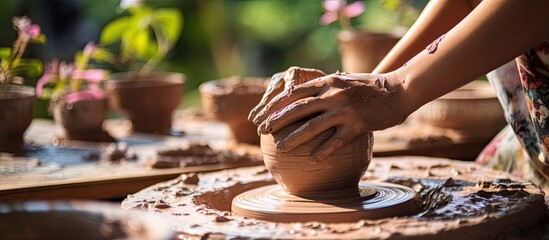 Potter's hands shaping clay in a pottery craft, photograph in vintage style with a soft toning effect, displaying artistry with copy space image.