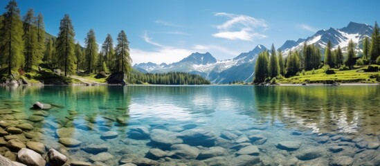 Wall Mural - Scenic mountain view with serene lake under sunny skies, with copy space image.