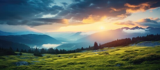Wall Mural - Mountain landscape with a foggy sunset or dawn, featuring grassy hills and a cloudy dramatic sky, offering a serene backdrop for a copy space image.