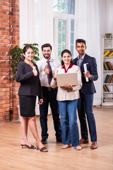 Wall Mural - Indian asian corporate people or colleagues discussing work on a laptop while standing in posh office