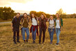 © Studio Romantic - Group of friends tourists trekking with backpacks during a walking tour in nature. People men and women on a hiking trip holiday standing in a row and looking at camera. Travel and tourism concept.