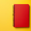 © Nasreen - A red notebook placed in the top right corner of a solid yellow background, ready for taking notes.