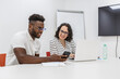 © Juan Algar - Two Colleagues Collaborating on a Project Using Laptop and Smartphone in a Modern Office
