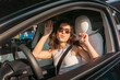 © Nataliya - Smiling young woman in sunglasses driving vehicle on the road on a bright day while listening the music. Travel adventure drive, happy summer vacation concept