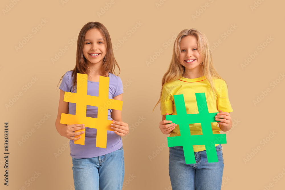 Cute girls with hashtags on beige background