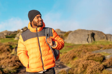 happy man tourist with backpack hiking and enjoying mountain landscape at sunset  