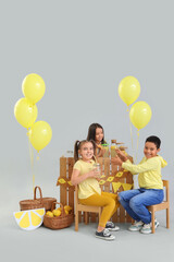 Wall Mural - Cute little children selling lemonade at stand on grey background