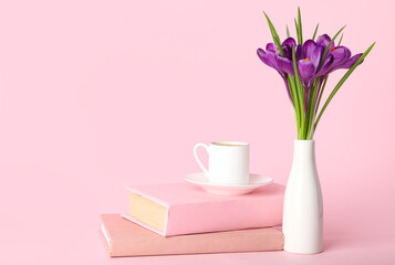 Wall Mural - Vase with beautiful crocus flowers, cup of coffee and books on pink background