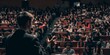 © Armin - A person delivers a talk to a full auditorium of attentive listeners, highlighting the dynamics of public speaking and the collective focus of an audience in formal academic gatherings.