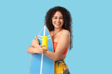 Poster - Young African-American woman with sunscreen cream and surfboard on blue background